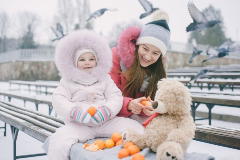 Mother and child in warm winter gear enjoying a snowy day in Canada, highlighting safe and cozy clothing essentials for snow days.